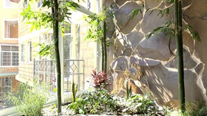 A stone wall with bamboo plants and a small garden area.