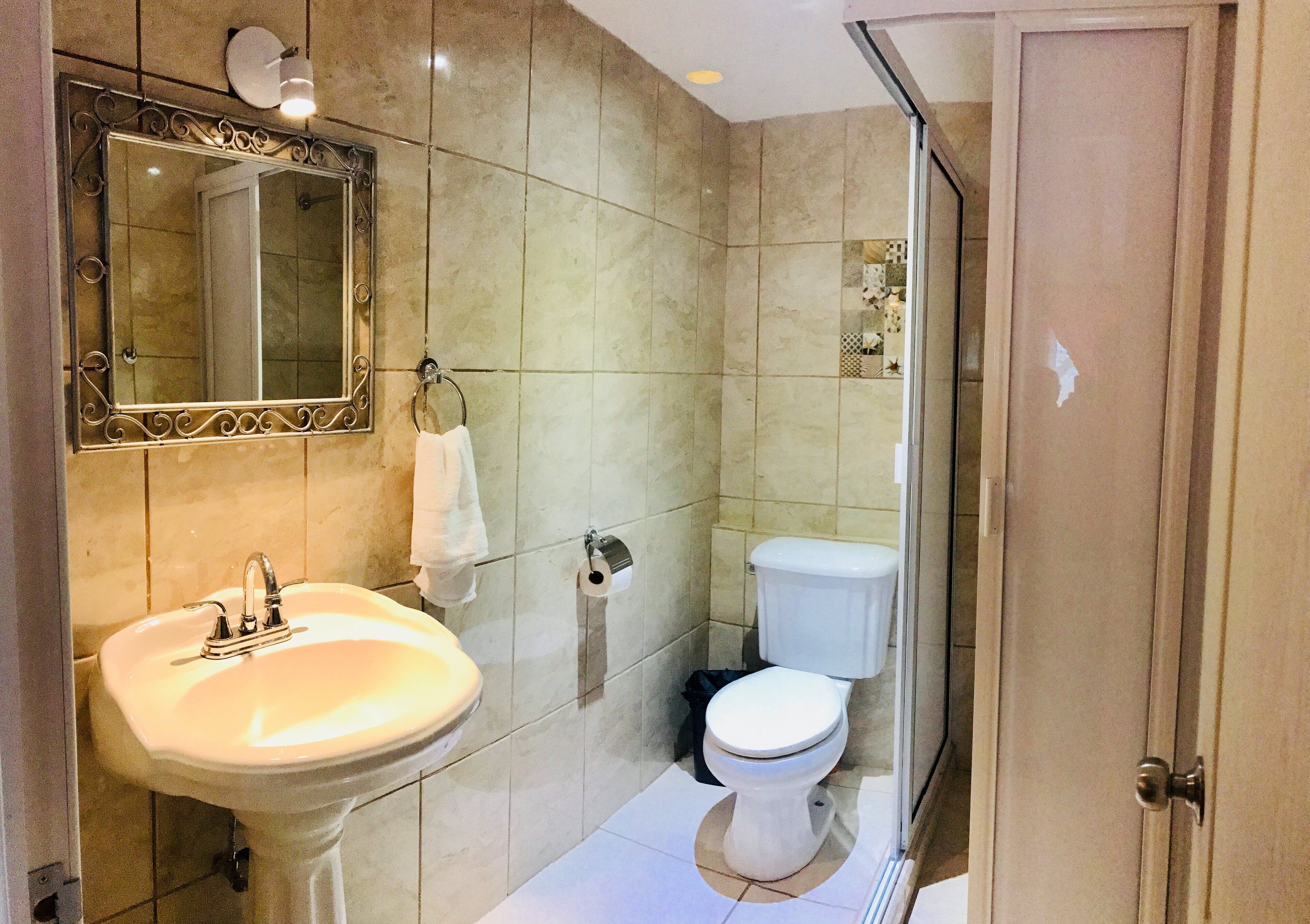 Une salle de bain avec un lavabo, des toilettes et un miroir.