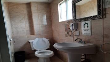 Un baño con inodoro, lavabo y ventana.