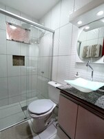 Ducha, cabezal de ducha tipo lluvia, toallas y papel higiénico
