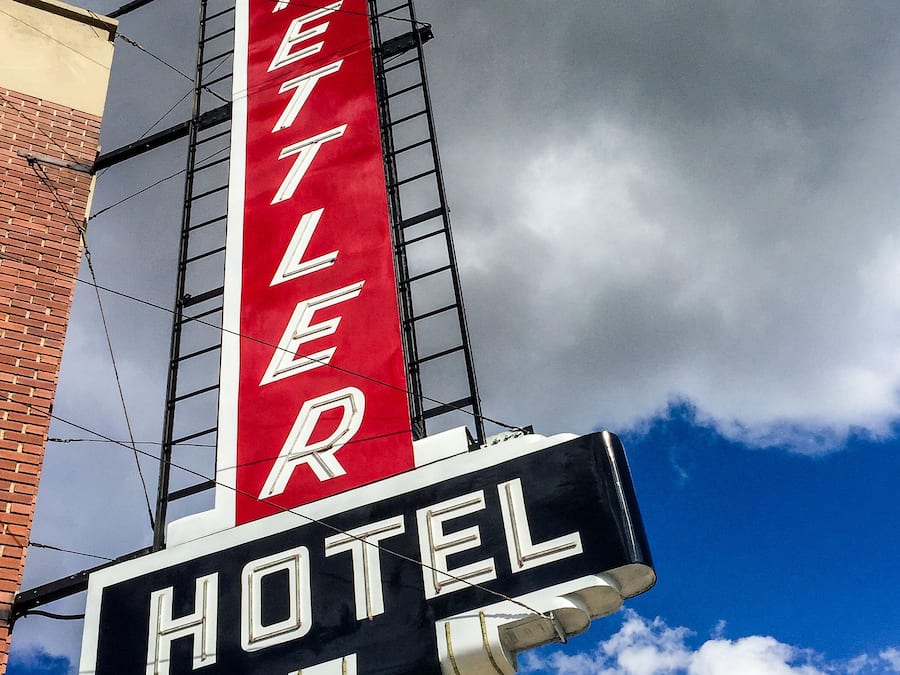 Hotellin kyltti, jossa valkoisilla kirjaimilla on teksti ”ETHELDER HOTEL”, ja taustana punainen väri. Kyltti on kiinnitetty mustaan rakenteeseen, jossa on myös tikapuut.