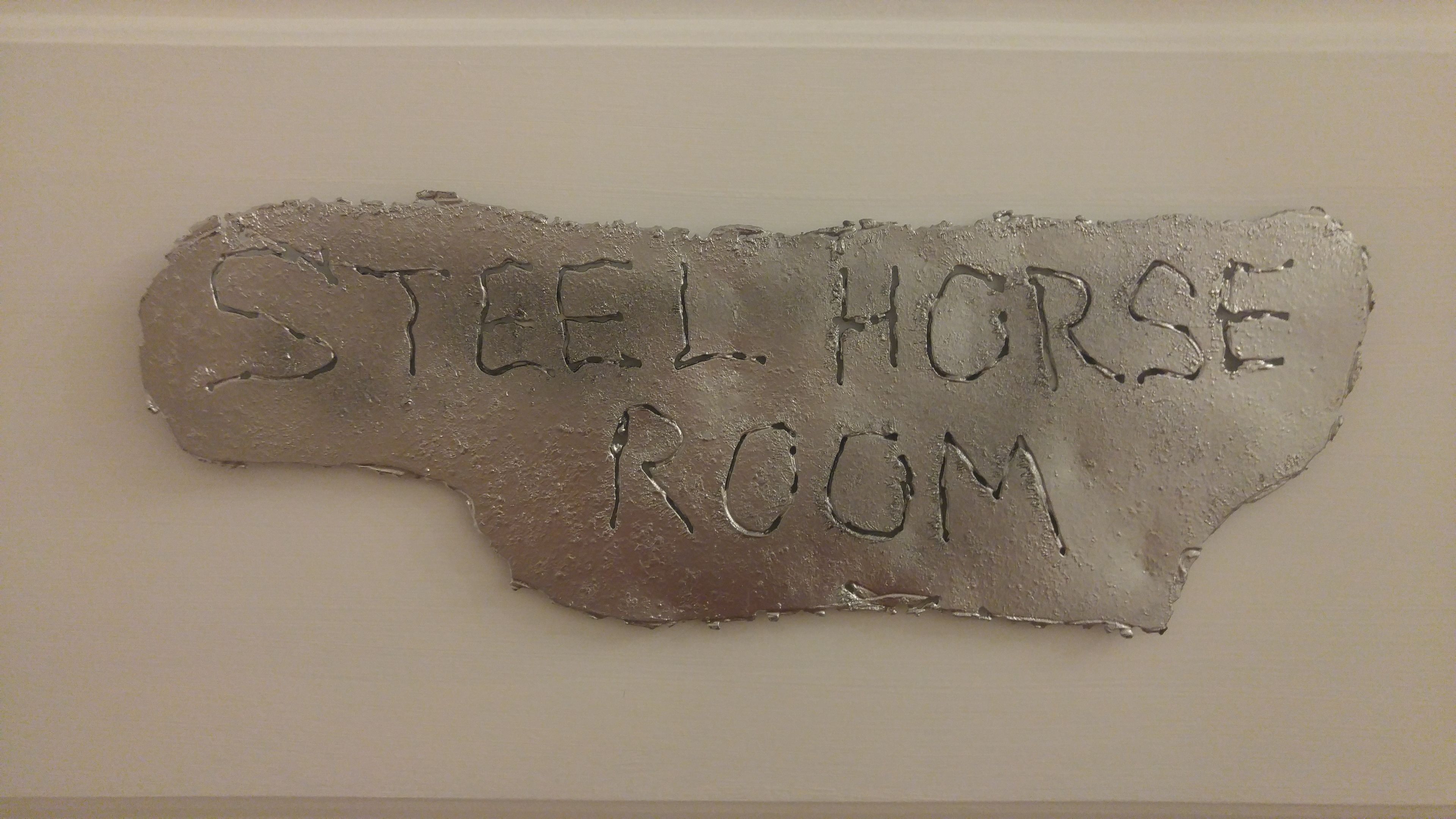 Un letrero con el texto 'STEEL HORSE ROOM'.