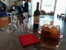 Una encimera de cocina con copas de vino, una botella y un recipiente para alimentos.