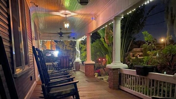 A covered porch with wooden chairs and a ceiling fan. - Kapp and Kappy B&B (Kissimmee)