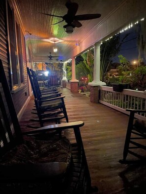 A covered porch with wooden chairs and a ceiling fan. - Kapp and Kappy B&B (Kissimmee)