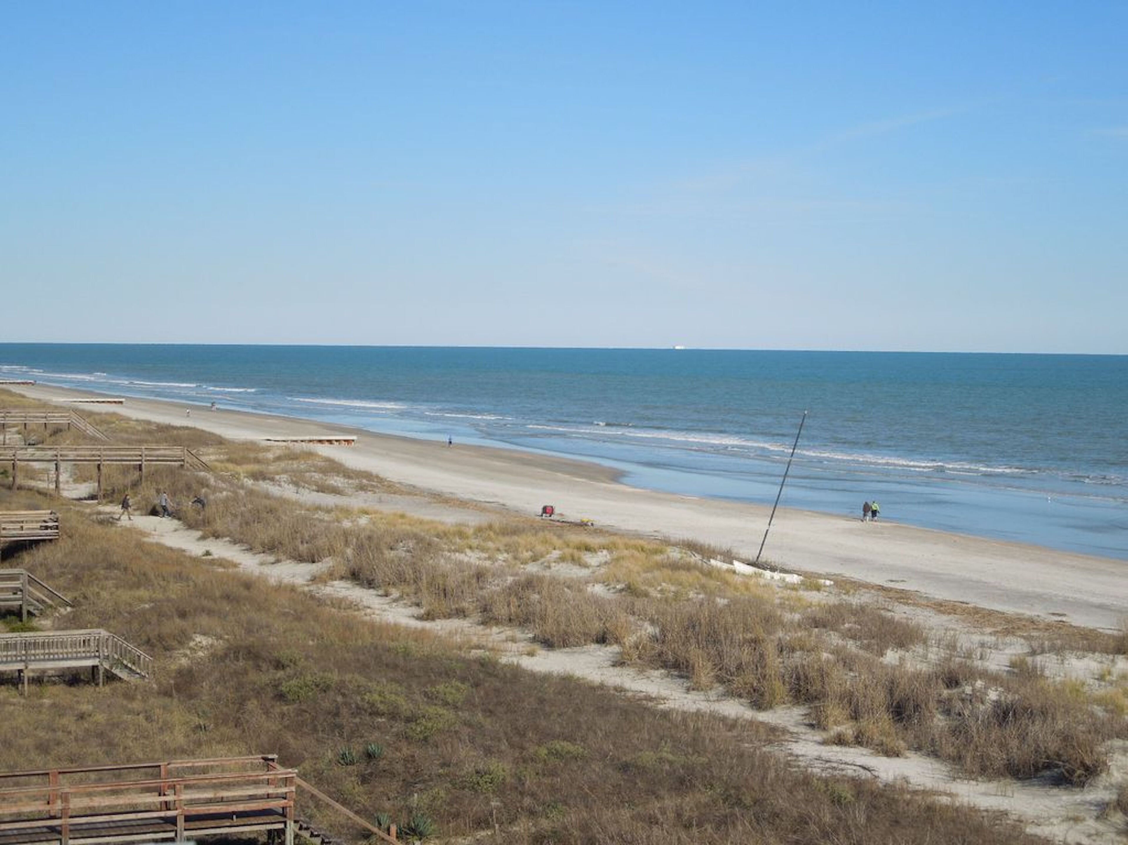 A beach with wooden walkways and a sandy shore.