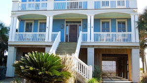 A two-story house with a front porch, a garage, and a large front yard.