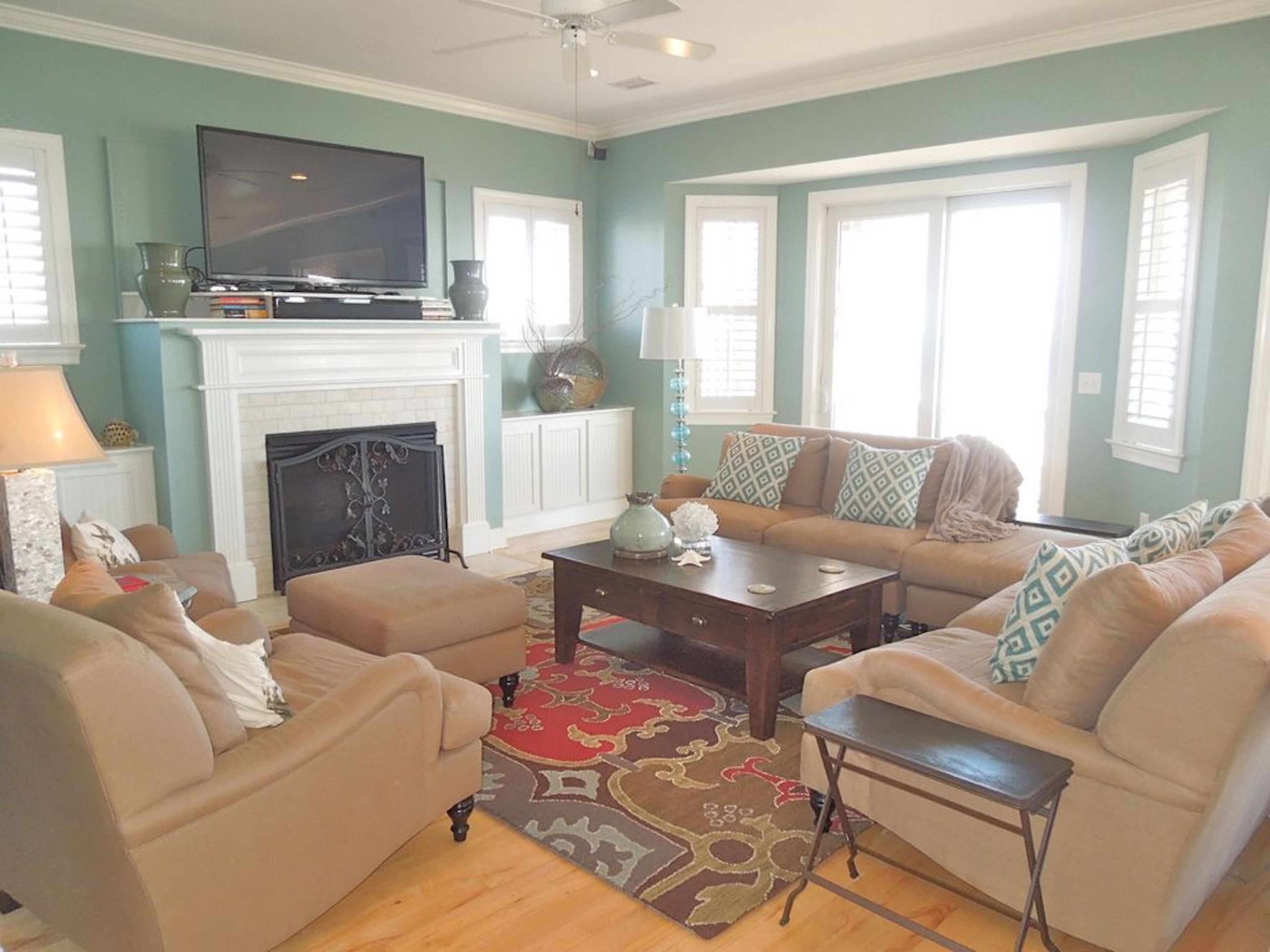 A living room with a fireplace, a television, and a sofa set.