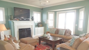A living room with a fireplace, a television, and a sofa set.