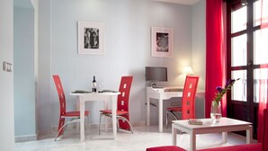 A modern apartment with a dining area, a workspace, and a seating area. - 2 bedrooms, private terrace (Sevilla)