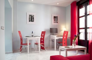 A modern apartment with a dining area, a workspace, and a seating area.