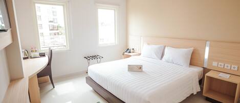 A modern hotel room with a large bed, a desk, and two windows.