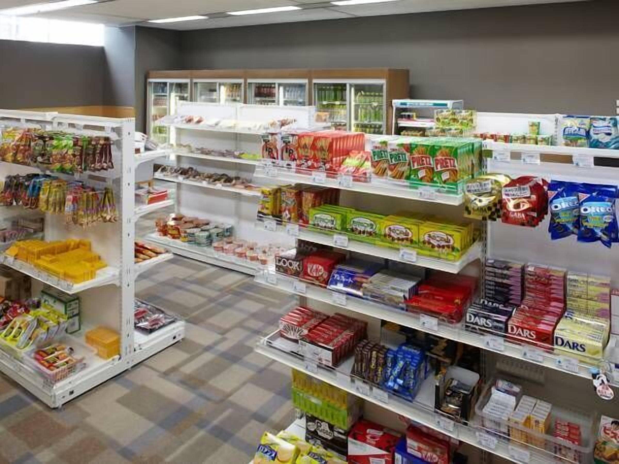 A grocery store with various food items on shelves and in freezers.