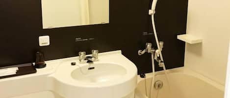 Un baño con lavamanos blanco, un espejo, pared negra y una bañera.