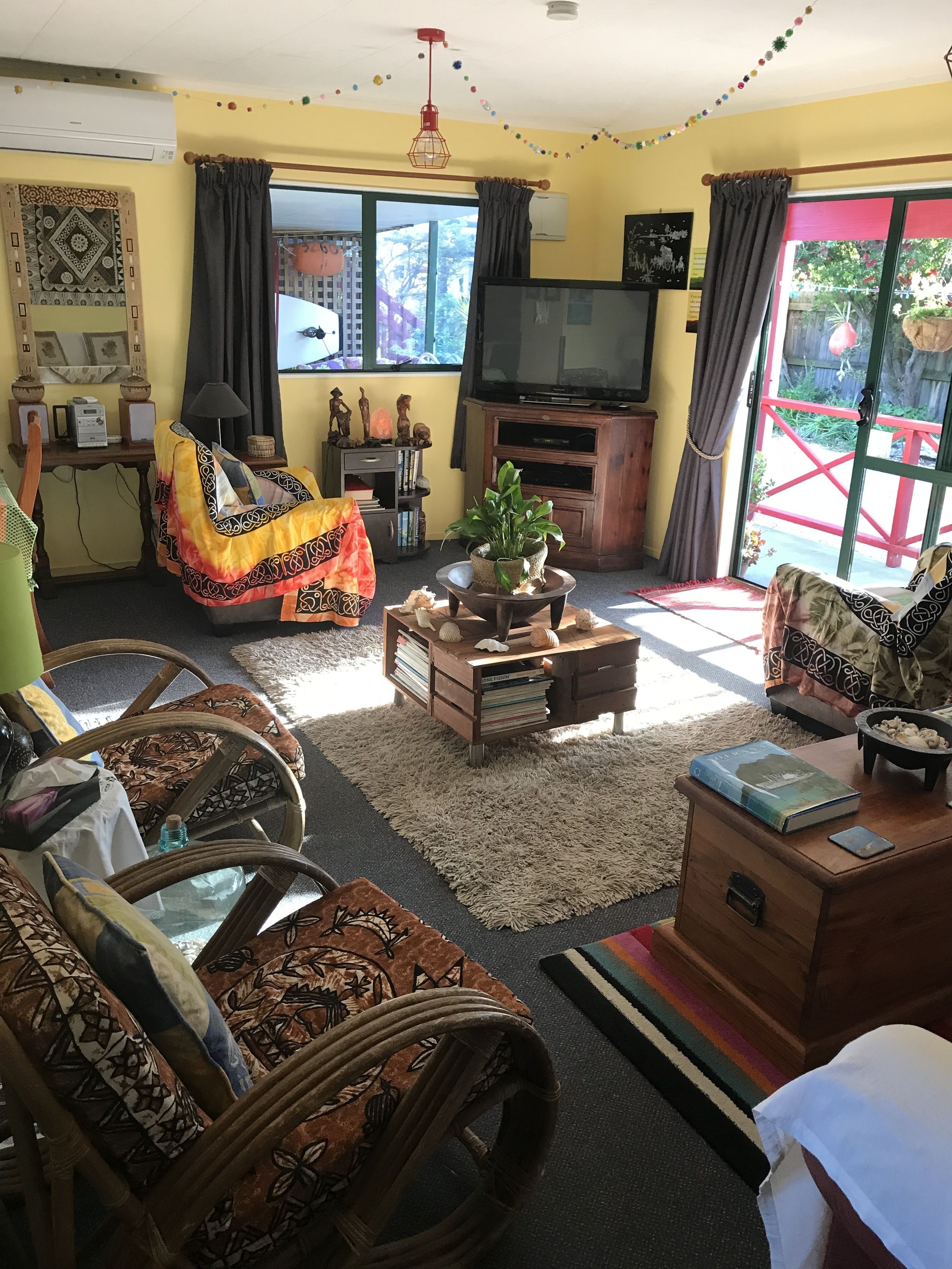 Una sala de estar con un sofá, una mesa de centro, un televisor y una estantería.