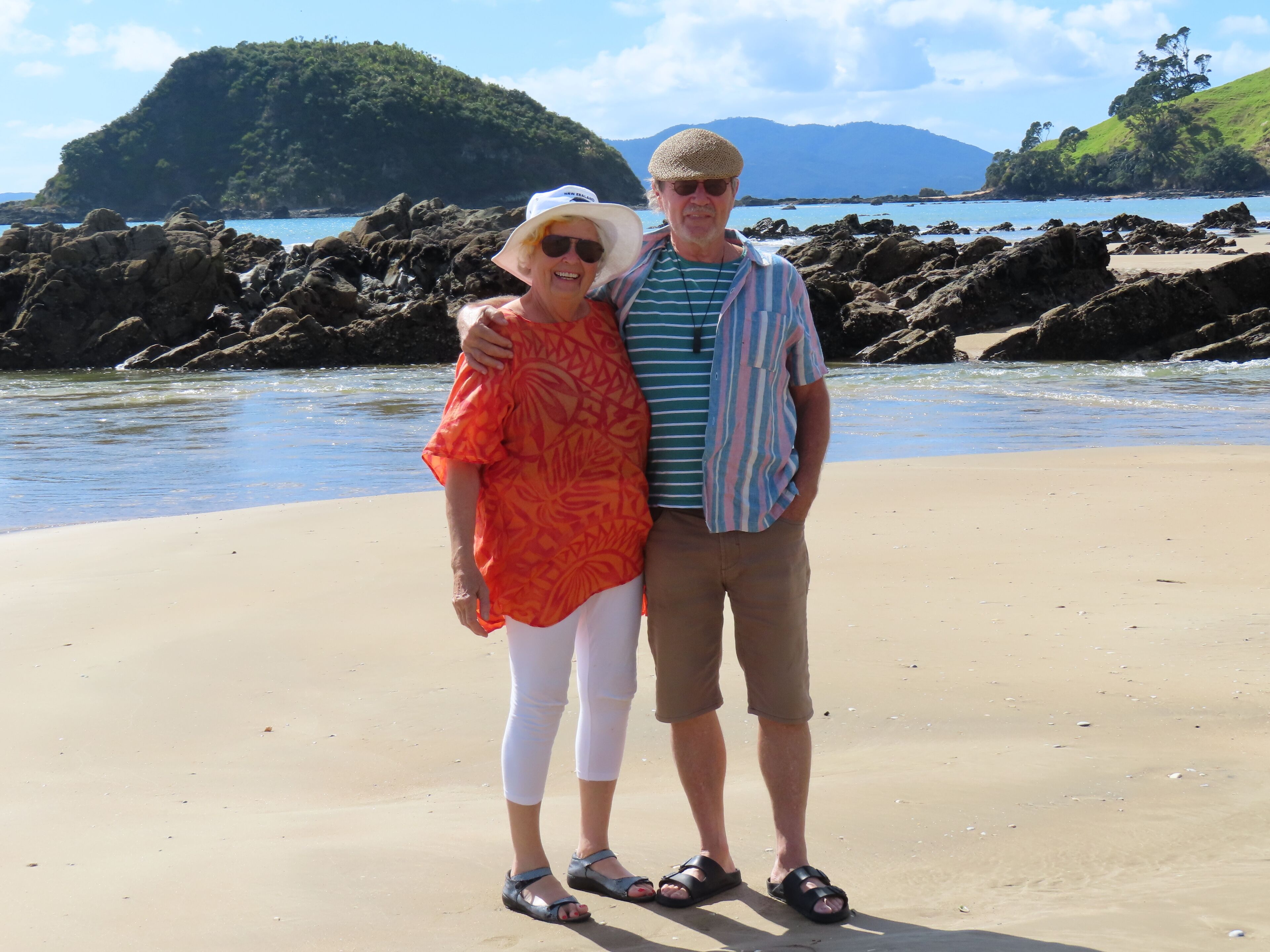 A beach with rocky formations and a clear view of the sea.