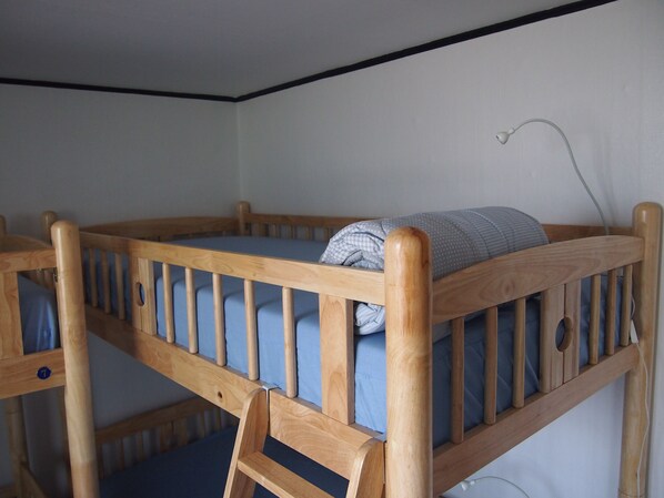 A bunk bed with a wooden frame and blue bedding. - GUESTHOUSE 345 - Hostel (Seoul)