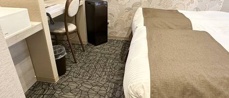 A hotel room with a bed, a desk, and a chair.