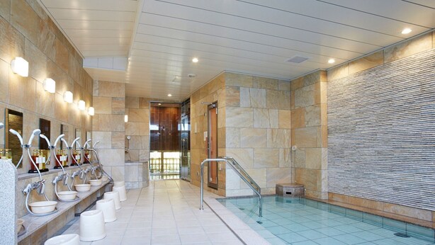 A modern indoor swimming pool with stone walls and a tiled floor. - S Training Center Hotel Osaka (Osaka)