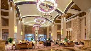 A spacious lobby with high ceilings, ornate chandeliers, and a central seating area with multiple tables and chairs. - Felton Grand Hotel Bazhong (Bazhong)