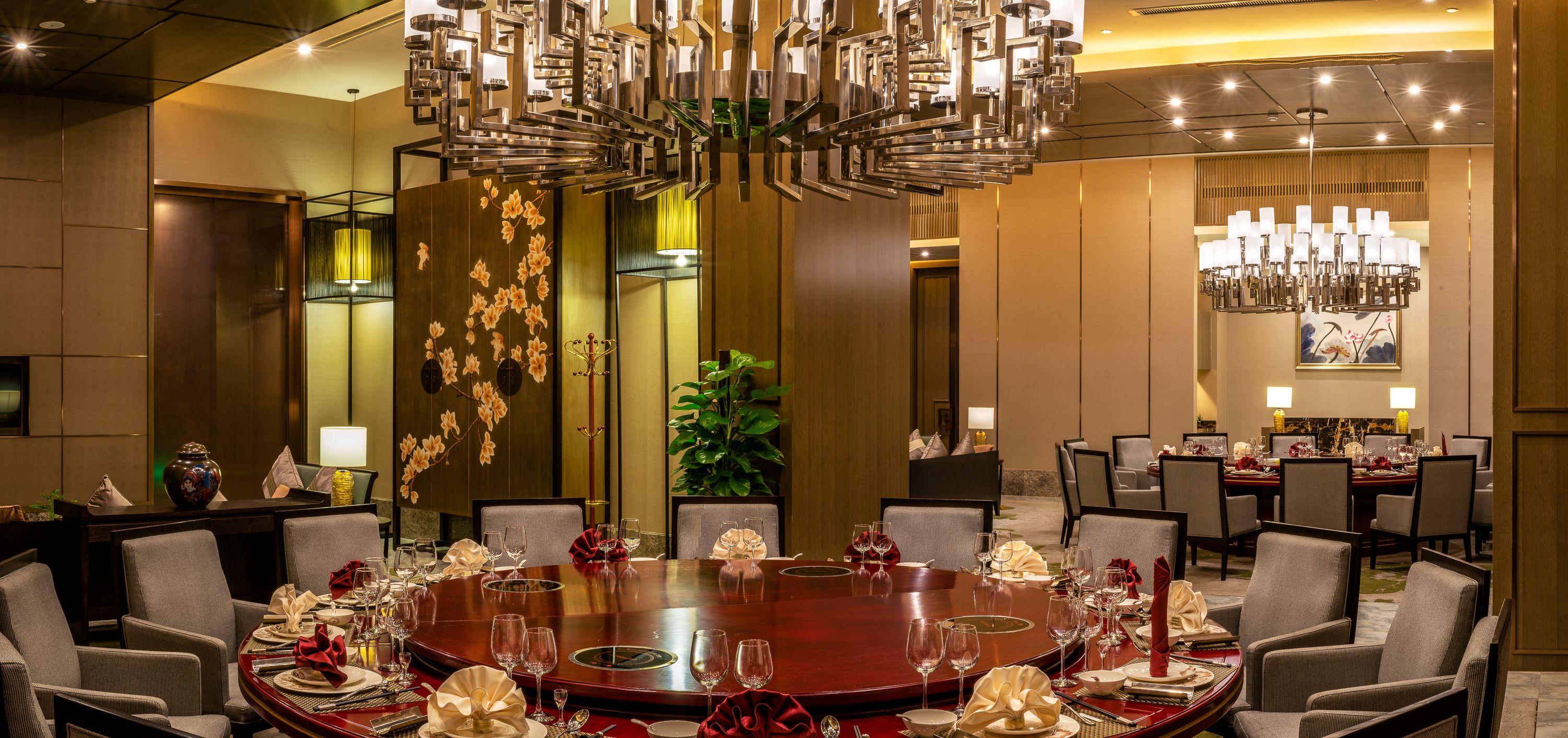 A dining area with a round table set for a meal, surrounded by chairs.