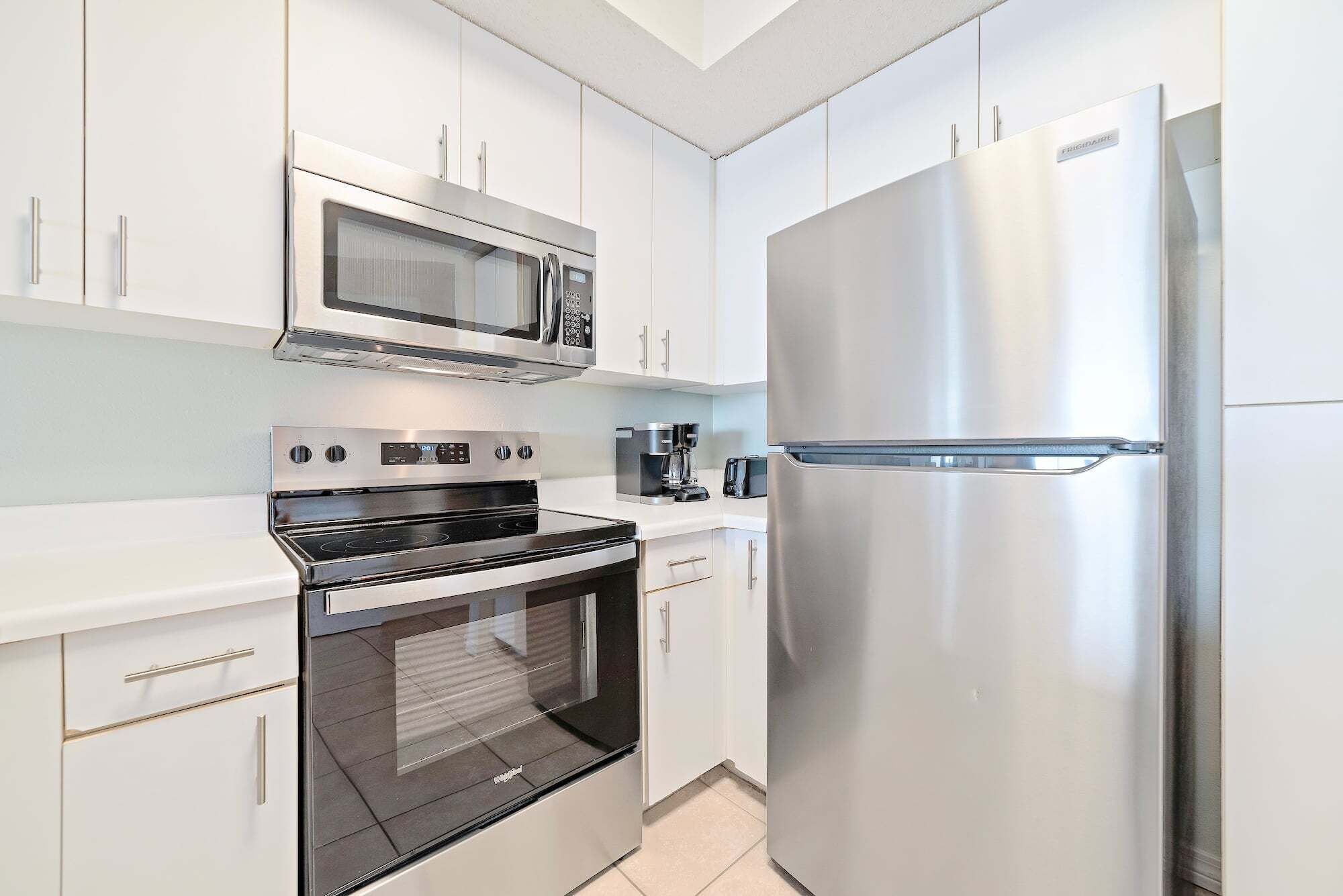 A modern kitchen with stainless steel appliances, including a microwave, oven, and refrigerator.