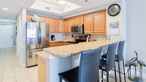 A modern kitchen with granite countertops, stainless steel appliances, and wooden cabinets.