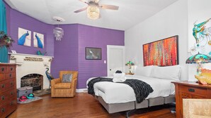 A bedroom with a bed, a chair, a fireplace, and a ceiling fan. - CLOSE TO DOWNTOWN- The Peacock Retreat- Dogs Stay Free  (Asheville)