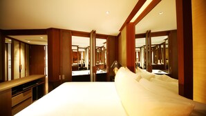 A hotel room with a large bed, a desk, and a mirror. - BaanSomprasong Condo Pattaya by Songland (Sattahip)