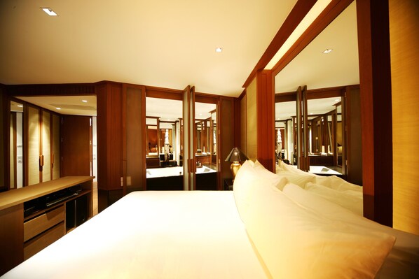 A hotel room with a large bed, a desk, and a mirror. - BaanSomprasong Condo Pattaya by Songland (Sattahip)