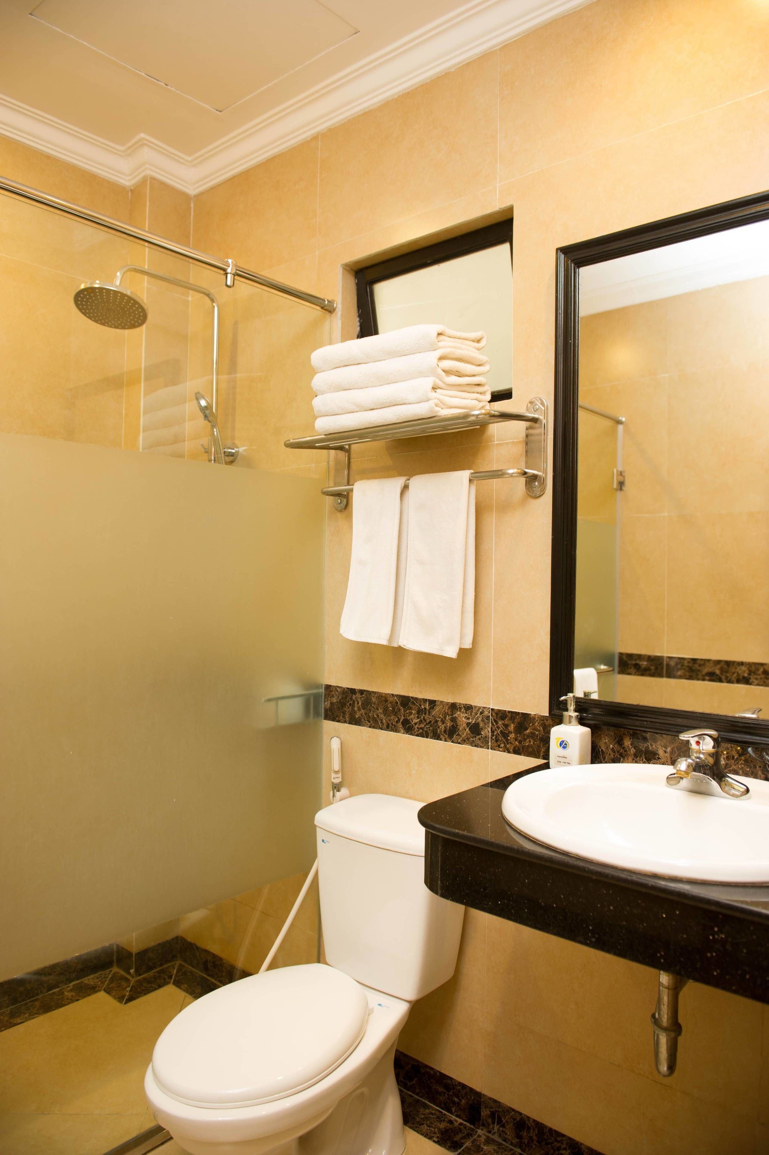 Un baño con inodoro, lavamanos y ducha.