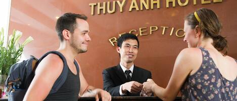 A reception desk at Thuy Anh Hotel with a receptionist.