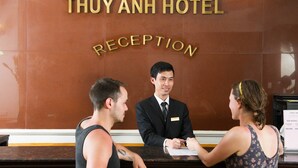 A reception desk at Thuy Anh Hotel with a staff member assisting guests. - Thuy Anh Hotel (Ninh Binh)