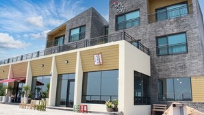 A modern building with a brick facade, large windows, and a flat roof. - Haemorat (Seogwipo)