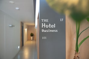 Un couloir avec une pancarte indiquant : « Les bases du secteur hôtelier ».