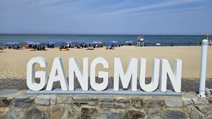 Een strand met de tekst 'GANGMUN' in grote letters.