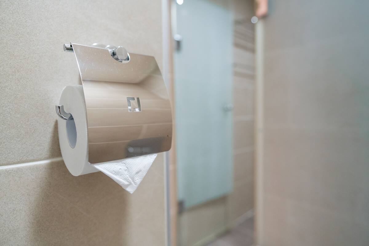 Un distributeur de papier toilette fixé au mur dans des toilettes.