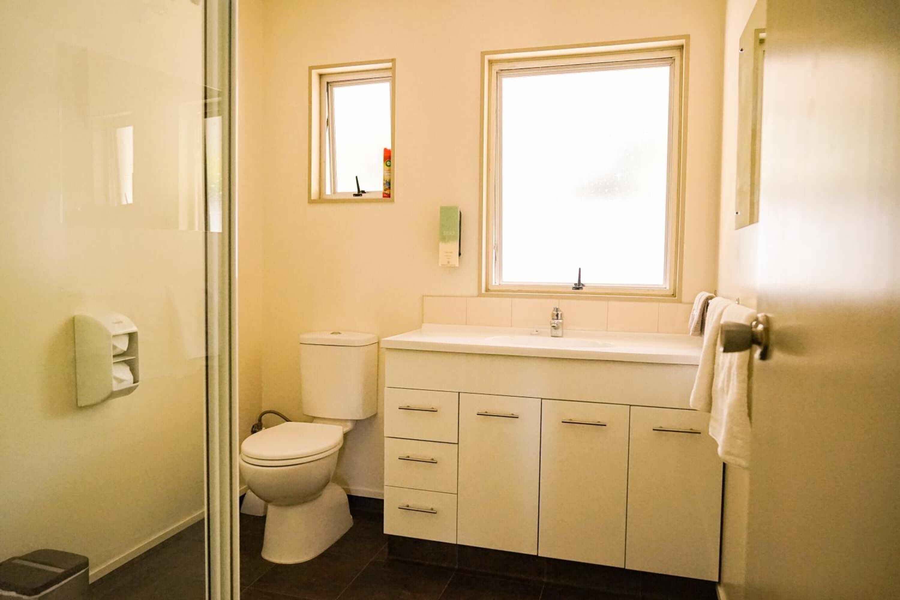 Un baño con inodoro, lavabo y ventana.