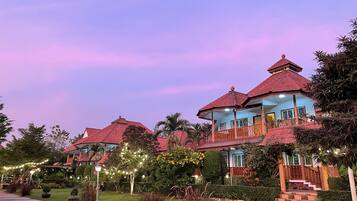 A series of traditional-style buildings with red roofs and multiple levels, surrounded by well-maintained gardens and pathways.