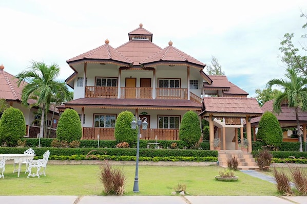 A two-story building with a traditional architectural style, featuring a balcony on the upper floor and a covered porch on the ground floor.