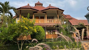 A large, two-story house with a balcony and a decorative roof.