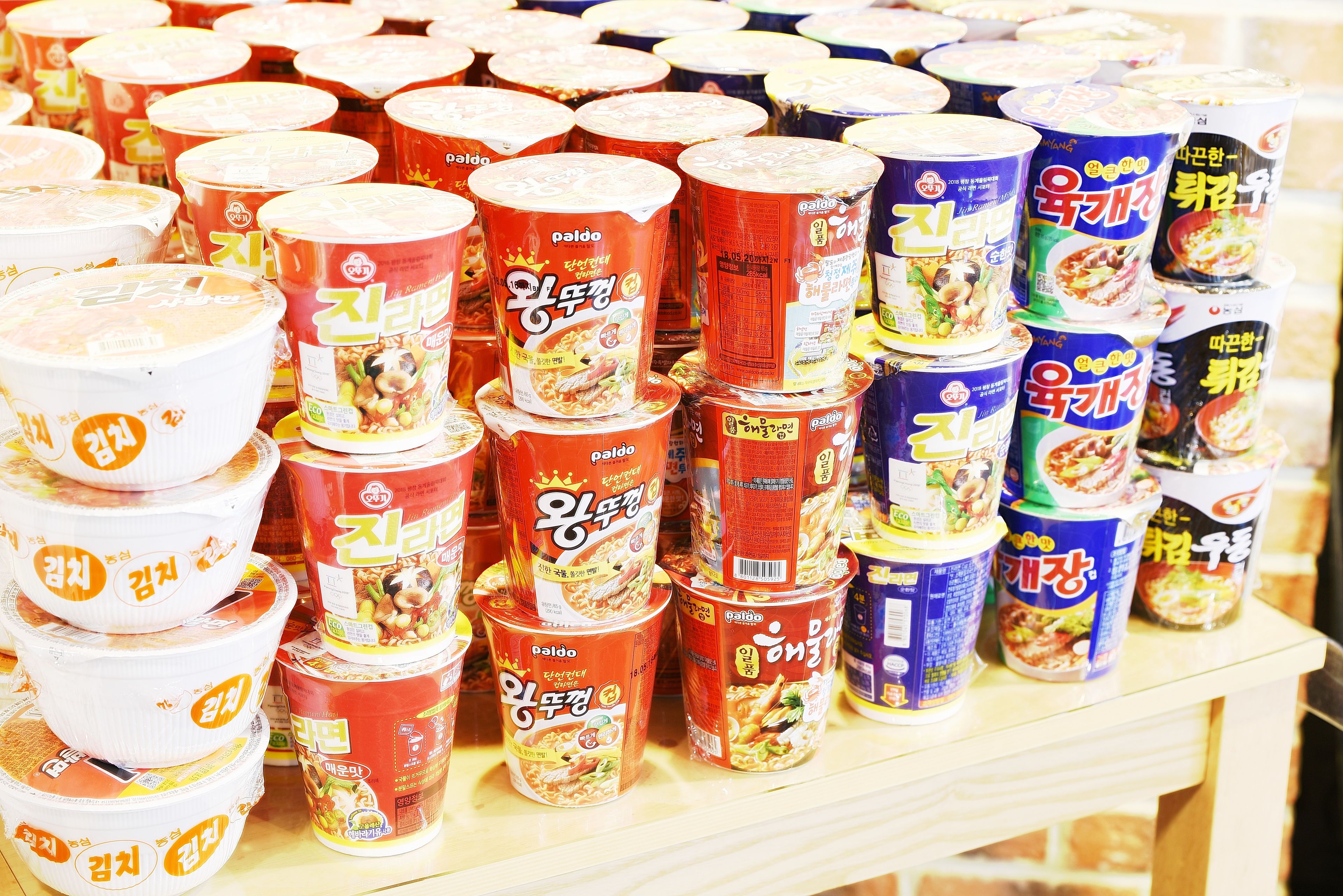 A variety of packaged food items, likely instant noodles, stacked on shelves.