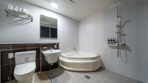 A modern bathroom with a toilet, sink, and bathtub. - Hotel Yaja Jecheon Station (Jecheon)