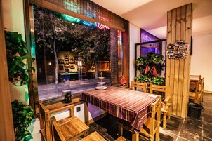 A cozy restaurant with a wooden interior, a table with a striped tablecloth, and a view of the street outside.