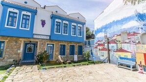 Un edificio con fachada azul, base de piedra y un letrero que dice "AYAPETRO".