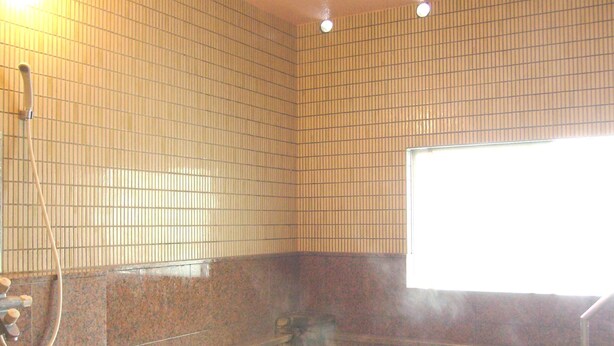 A hot spring bath with tiled walls and a window. - Hotel Senke (Myoko)