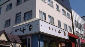 A building with multiple floors, featuring a sign with Japanese characters. - Hotel Senke (Myoko)