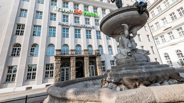 A historic building with a fountain in front, labeled "Travel24 Hotel" and "RING MESSHEHAUS". - Travel24 Hotel (Leipzig)
