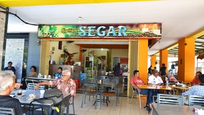 Un restaurant appelé « Kopifiam SEGAR » qui dispose d’une terrasse et accueille une clientèle variée.