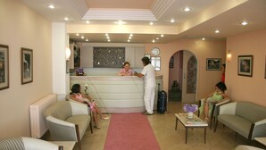 A hotel lobby with a reception desk, seating area, and a clock on the wall. - Prestij Apart Hotel (Akcakoca)